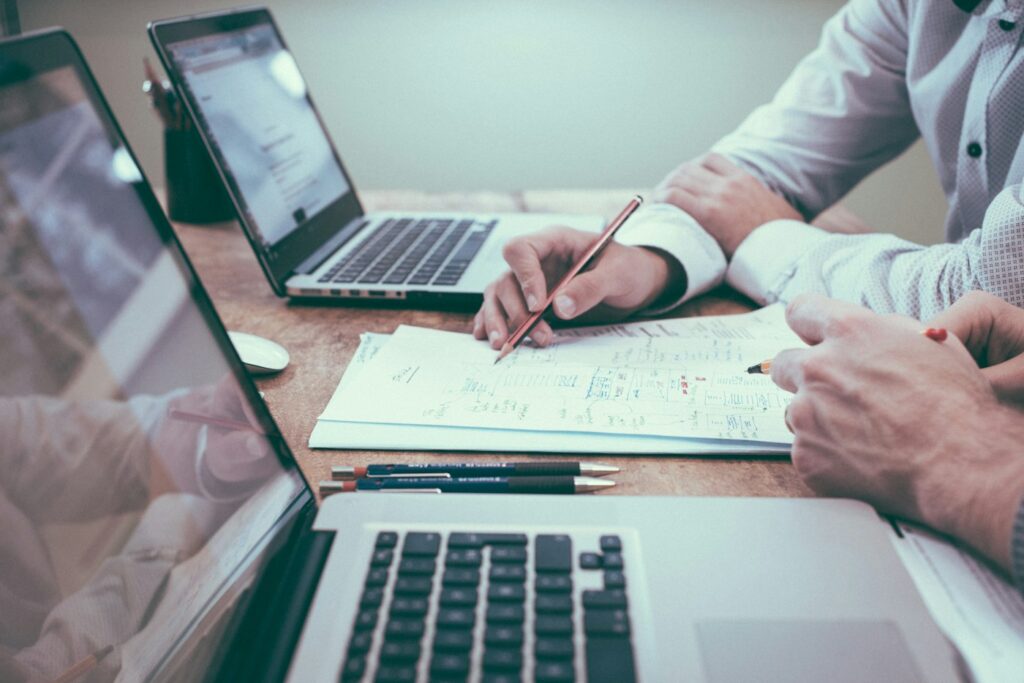 Mesa de trabajo con documentos y un portátil para planificar una estrategia digital